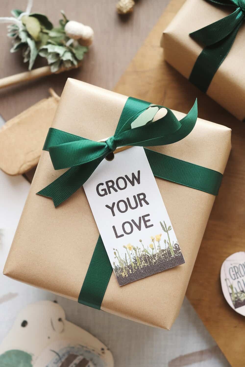 A beautifully wrapped gift with a seed paper tag that says 'GROW YOUR LOVE'.