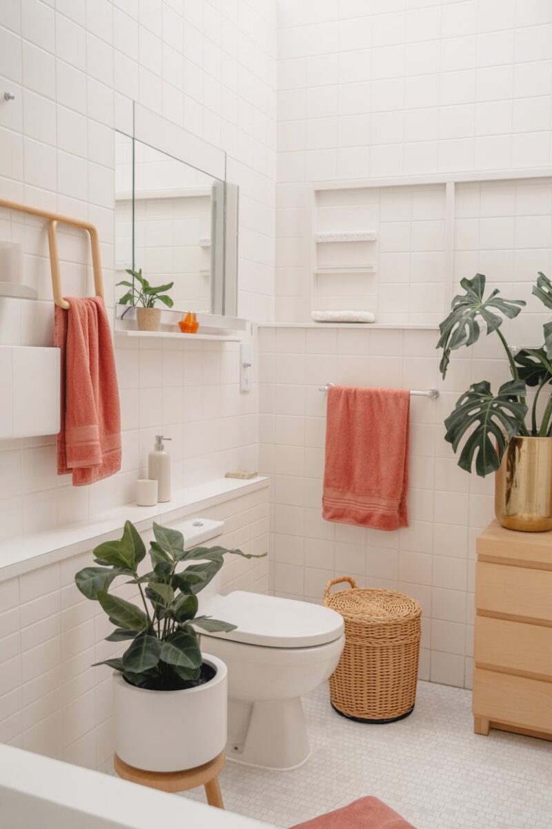 A bright bathroom featuring colorful towels, plants, and a clean aesthetic.