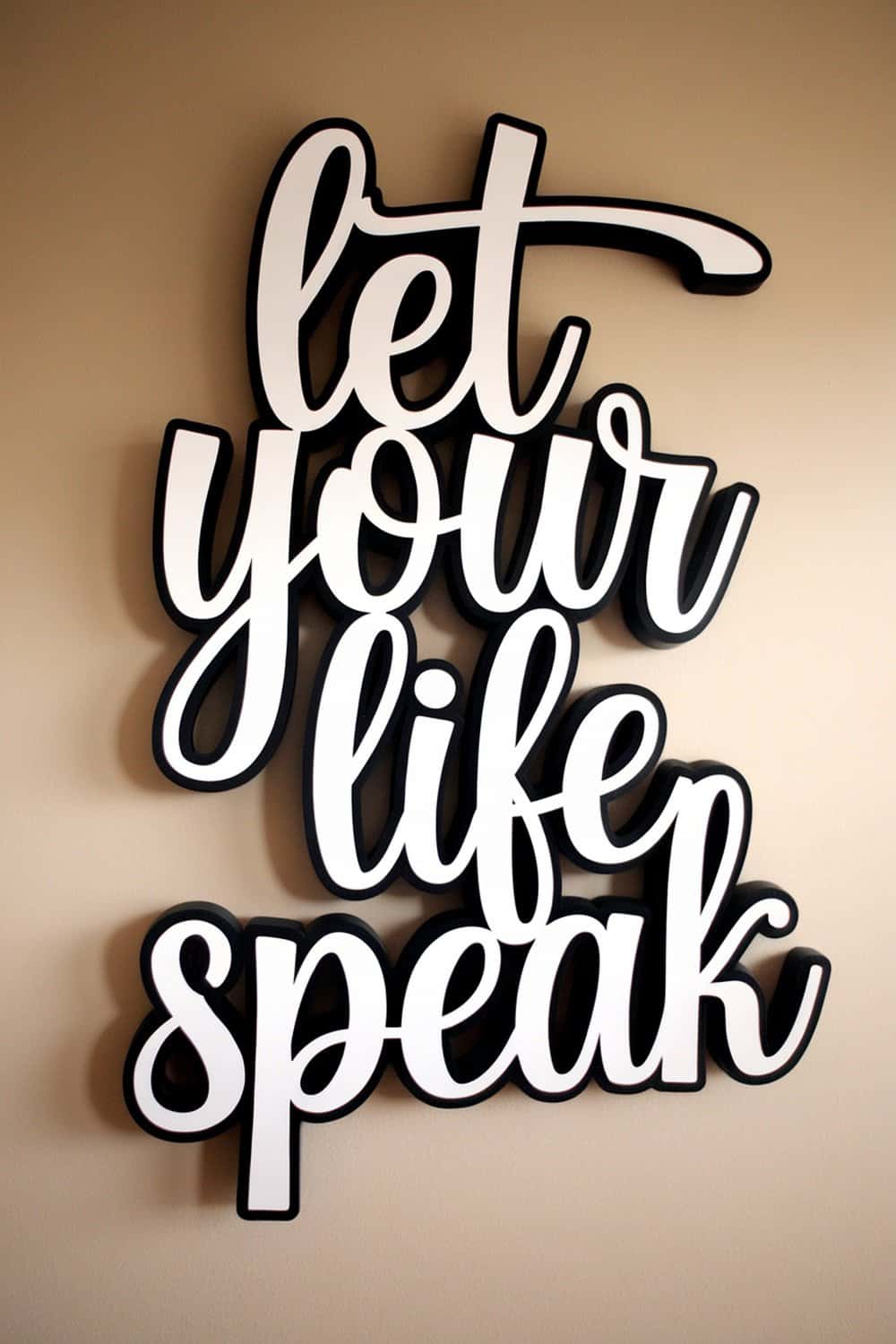 A decorative wall art piece with the phrase 'let your life speak' in stylish typography.
