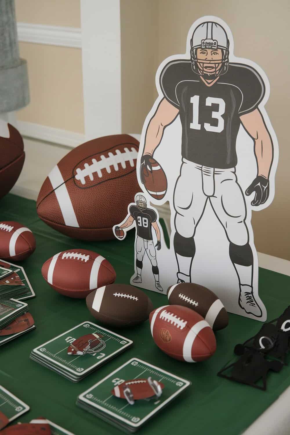 Table decorated with football-themed games and decorations, including mini footballs and player cutouts.