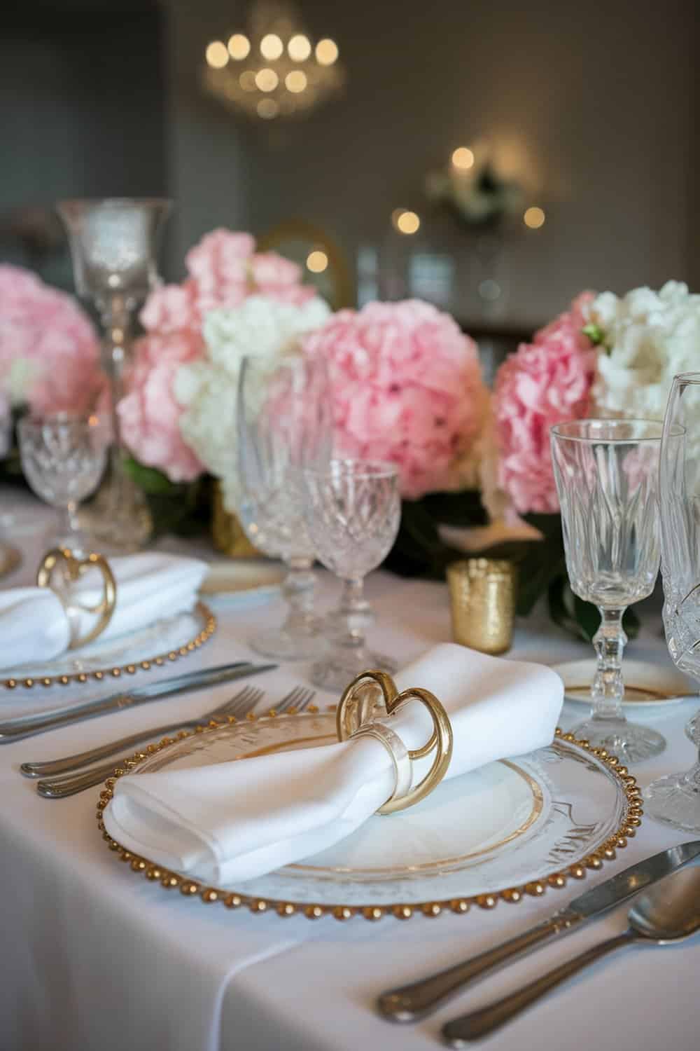 Elegant table setting with chic napkin rings and floral arrangements for Valentine's Day.